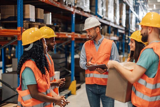 Diverse warehouse team discusses strategy for operations