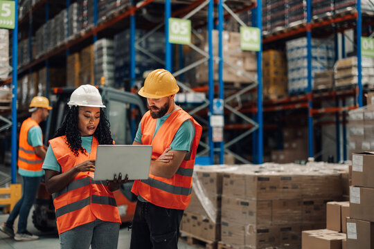 Focused diverse team members reviewing warehouse data on computer - Powered by Adobe