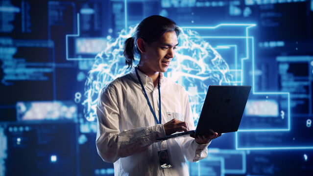 Smiling engineer in data center using artificial intelligence computing simulating human brain thought processes in computerized model. Happy worker works on laptop with AI machine learning algorithms
