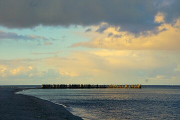 Panorama przedstawiająca Morze Bałtyckie. Przepiękna panorama na Bałtyk. W oddali widać falochrony i chmury zapowiadające deszcz. © Adam