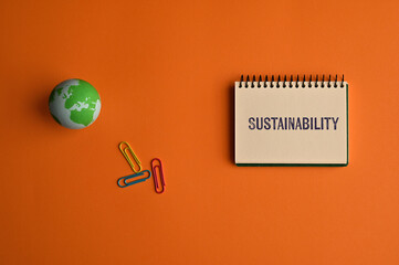 There is notebook with the word Sustainability. It is as an eye-catching image.