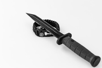 Army knife and paracord bracelet on a white background, black and white photo
