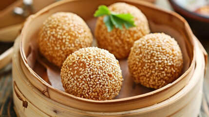 Deep fried sesame balls filled with lotus paste, served in bamboo steamer, create delightful culinary experience.