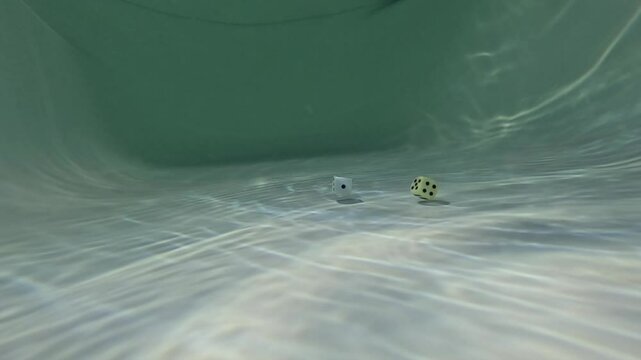 Three dice gradually sinking beneath crystal clear water. concept of gambling - Powered by Adobe