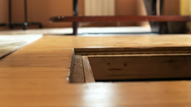 close-up of opening wooden trap door of a cellar in the floor