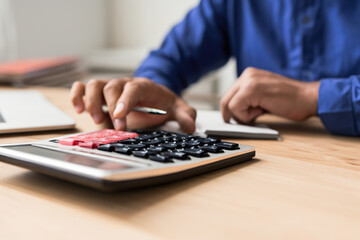 Man use calculators and documents that calculate expenses in the home office