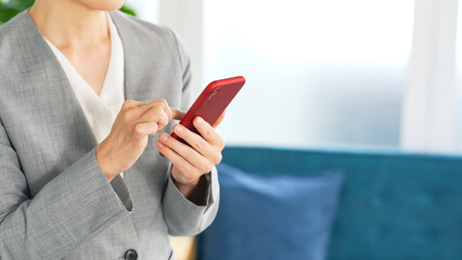 オフィスでスマホを使う女性ビジネスパーソン