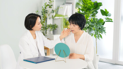 Obraz premium メイクのアドバイスを受けるミドル女性 ビューティーアドバイザー