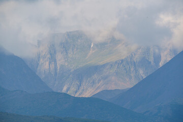 Misty mountain peaks under a cloudy sky