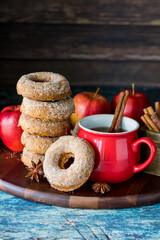 A stack of homemade doughnuts served with spiced hot apple cider.