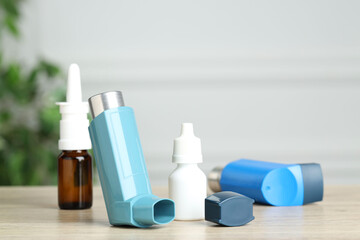 Different asthma medications on wooden table, closeup
