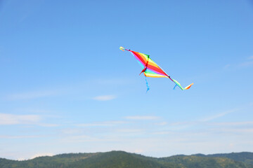 One colorful kite flying in blue sky