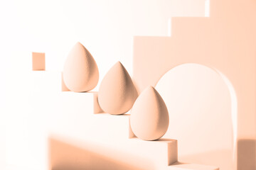 Stylish presentation of makeup sponges on white background, toned in peach fuzz color