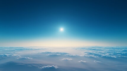 A panoramic landscape with a rich blue sky above sparse clouds, the sun a tiny bright point near the horizon