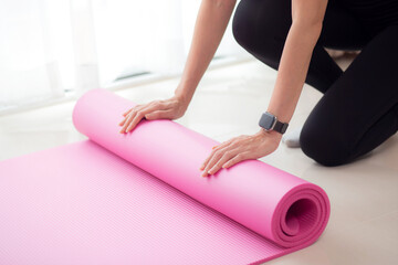 Closeup hands of young woman rolling with mat yoga on floor for preparation meditation and exercise for recreation at home, training workout and practice yoga with activity and hobbies for health.