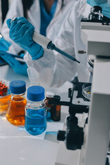 Fototapeta premium Scientist using microscope in laboratory. Close-up of a researcher's hands adjusting a modern microscope in a lab setting. Science concept