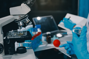 Scientist using microscope in laboratory. Close-up of a researcher's hands adjusting a modern microscope in a lab setting. Science concept