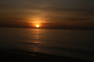 The sun rises at the sea in the morning.