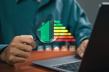 Energy efficiency concept, Businessman using laptop with energy efficiency rating icons for energy...