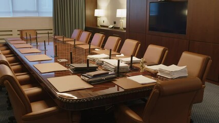 Interior of conference room with large wooden table surrounded by leather chairs ready for meeting of lawyers