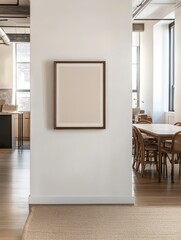 A minimalist room featuring a blank framed canvas on a wall, with a wooden table and chairs in the background, creating a serene and open atmosphere.