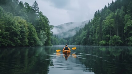 A person kayaking on a serene lake surrounded by forests with
