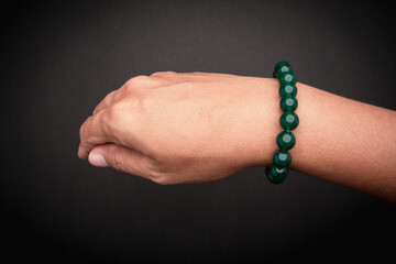 Close-up of green bead bracelet on wrist.