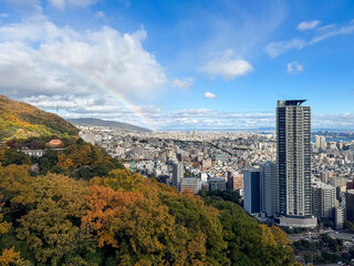 Stunning panoramic view of Kobe city with a vibrant rainbow.