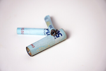 The roll like cigarette of 50 thousand rupiah. 50000 is the second largest banknote denomination in Indonesia.