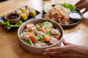 A close-up of a waitress serving food at a table in a restaurant.
