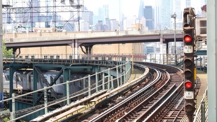 Fototapeta premium New York subway station. Metro train on metropolitan platform. United States public transportation. Elevated Queensboro Plaza railway line, Queens. NYC Manhattan skyline, highrise skyscraper cityscape