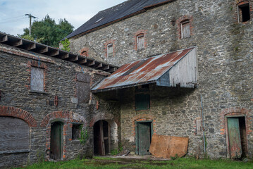 Ruins of an abandoned, industrial building shows crumbling stone and brick. Photo taken in...