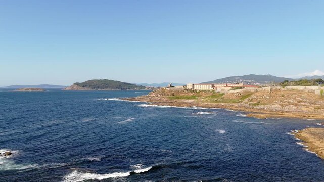 aerial - view of Monterreal Castle on the Baiona coastline, surrounded by rocky shores