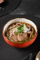 Vietnamese Beef Pho Bo Soup in Ceramic Bowl with Sliced Meat and Fresh Herbs – High Contrast and...
