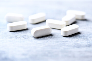 Amino acids tablets. Nutrition for bodybuilding. Fitness supplements on bright wooden background. Soft focus. Copy space.	