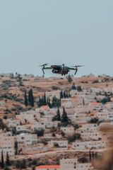 Fototapeta premium A drone flies over a small village nestled in the hills.