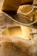 Advertising template photo with luxury concept, close-up shot from above a sandbank with gold...