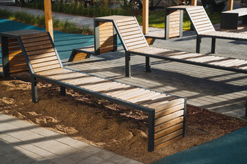 Obraz premium A row of wooden lounge chairs are sitting in the sand near a pool