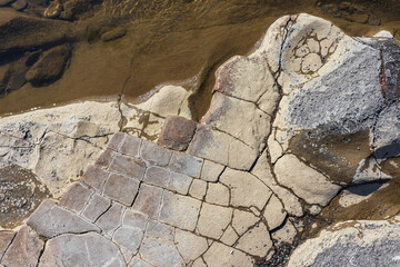 the structure of the bottom is a shallow mountain river, an old man and nature walks, a sunny day