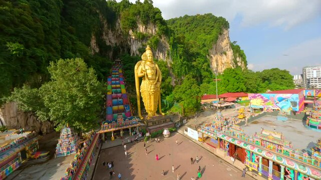 Cinematic FPV shot of Batu Caves and gold statue of Murugan in Kuala Lumpur, Malaysia