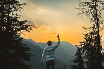Man tourist stands on a rock with arms raised. Beautiful landscape of the Himachal Pradesh Sunrise...