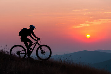 Obraz premium Man on mountain bike against sundown sky silhouette