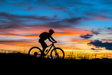 Fototapeta premium Man on mountain bike against sundown sky silhouette