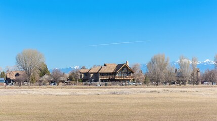 Obraz premium A large, modern home with a wooden exterior sits on a grassy hill overlooking a valley in the distance.