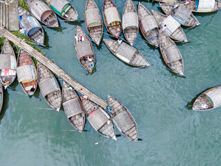 Aerial view of boatmen navigate their vessel across the Shitalakshya River, carrying passengers...