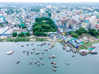 Aerial view of boatmen navigate their vessel across the Shitalakshya River, carrying passengers...