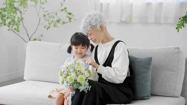 花束を持った孫と祖母　ファミリーイメージ