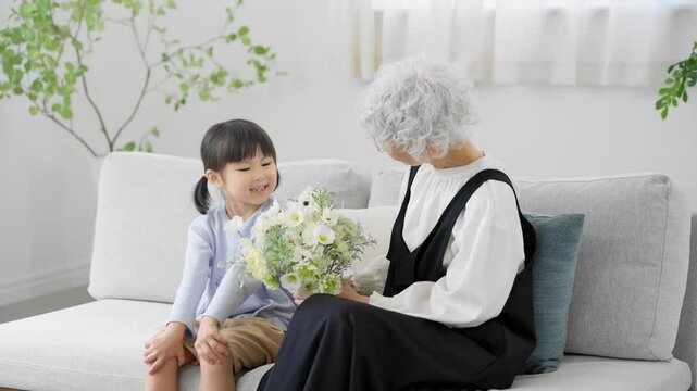 花束を持った孫と祖母　ファミリーイメージ