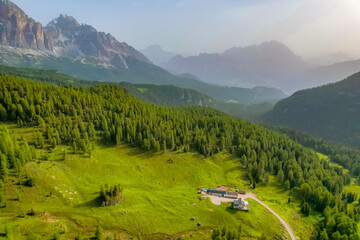 Snake Road in the Dolomites. Sunrise aerial forest. Pathway from Snake Road to high mountain range...