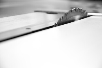 Naklejka premium Black and white picture of Circular saw blade cutting wood in a
